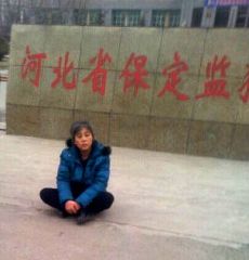 悲愤的郑祥星妻子孙素云坐在保定监狱外冰冷水泥地上，向社会呼救