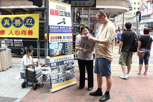 图：法轮功学员小红满脸笑容讲真相，赢得不少人签名举报江泽民。