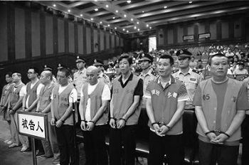 张卫国（右一）等九名被告人被带上法庭受审。