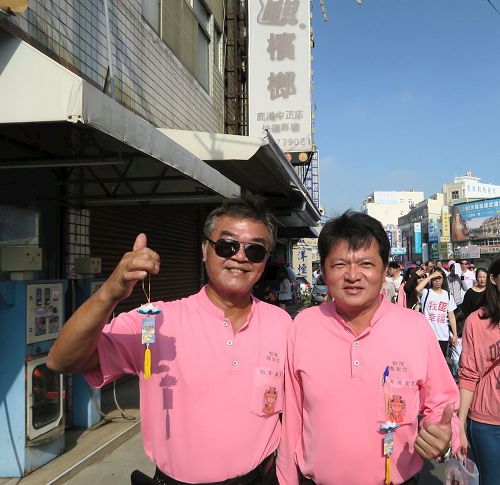 '图6：彰化县招福功德会理事长谢宏明（右）与朋友开心的展示挂有“法轮大法好”的莲花吊饰。'