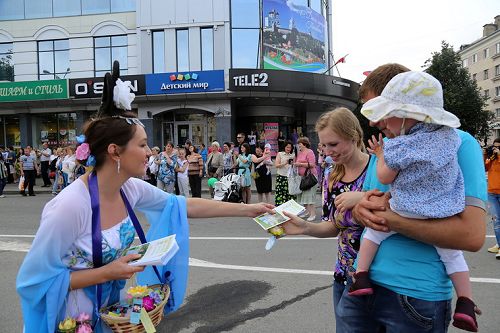 图6：参加普斯科夫城市日的大游行活动，法轮功学员沿途派发功法介绍传单