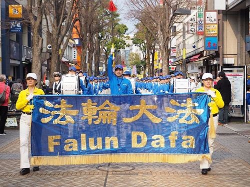 '图1：三月十九日，来自日本各地的法轮功学员齐聚横滨举行了游行活动，图为游行队伍经过横滨中心部的关内的场景'