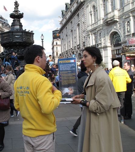 '图18：二零一七年四月二十二日，英国女士碧丽在皮卡迪利广场第一次听闻法轮功，签名反迫害，并表示有兴趣'