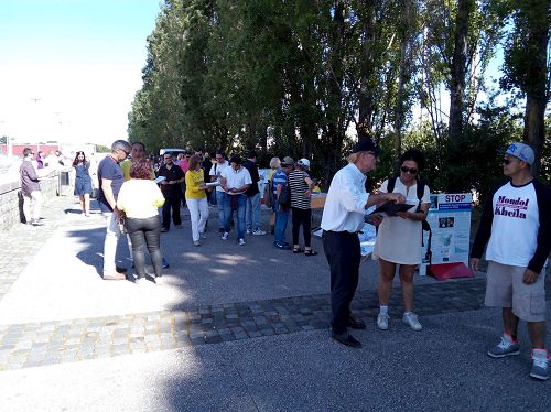 '图1，葡萄牙法轮功学员在里斯本世博会公园举办活动讲真相，庆祝世界法轮大法日'