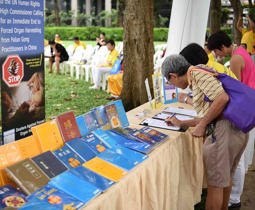 '图7～9：二零一七年五月二日，新加坡法轮功学员在芳林公园庆祝即将来临的世界法轮大法日。图为各族裔民众了解真相后签名支持法轮功学员反迫害。'