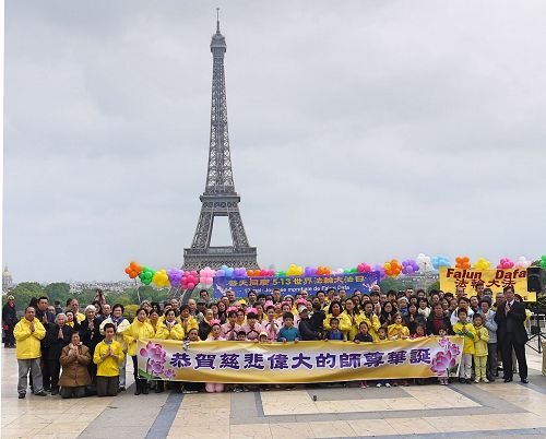 '图1：法国部份法轮功学员聚集在艾菲尔铁塔下的人权广场，庆祝法轮大法洪传世界二十五周年，同时向法轮功创始人李洪志先生恭祝生日快乐。'