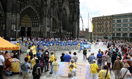 法轮功学员组成的天国乐团在科隆大教堂前表演，吸引了众多游客。