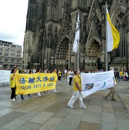 法轮功学员在科隆举办游行，背景是著名的科隆大教堂。