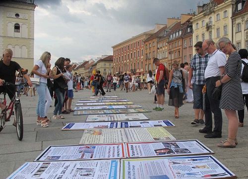 '图9：波兰市民游客观看法轮功真相展板'