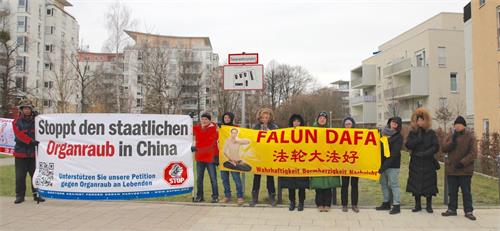 '图3：来自德国和奥地利的法轮功学员顶着冷冽的强风，在慕尼黑中领馆前举办活动。'