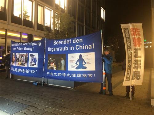 '图：二零一八年十一月二十六日晚，法轮功学员在汉堡市中心，经济峰会举办招待会的Esplanade街上，竖立起有夜间照明灯的大型彩色横幅，希望能引起人们关注正在中国发生的活摘器官罪行。'