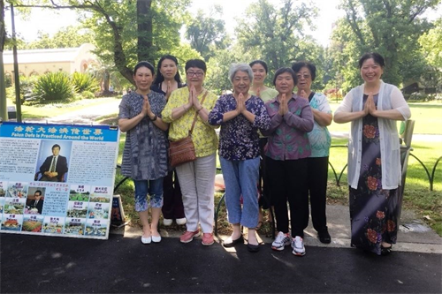 '图2：二零一八年十二月二十七日，墨尔本著名旅游景点费茨罗伊公园（Fitzroy　Gardens）真相点的法轮功学员恭祝师尊新年好。'