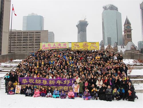 '图1～2：中国新年即将来临之际，多伦多法轮功学员聚集市政厅前给慈悲伟大的师父拜年，恭祝师父新年好！'