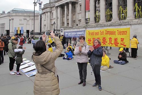 图10：二零一八年三月二十四日，在伦敦特拉法加广场，三位来自某东欧国家的游客在法轮功学员讲真相现场留影，并签名支持法轮功反迫害。