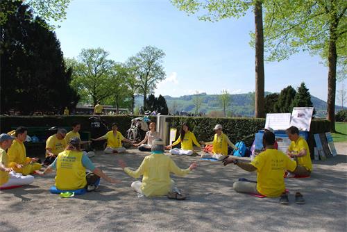 '图1：瑞士法轮功学员在景点玫瑰园集体炼功，告诉人们法轮功的美好'
