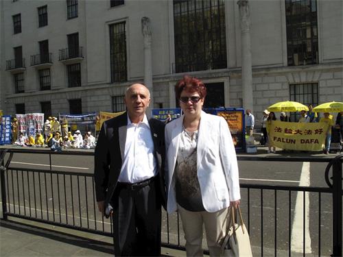 '图12：退休意大利语教师（Nicolo）和太太在去BBC参加活动的路上遇到法轮功学员在中使馆前举行的新闻发布会'