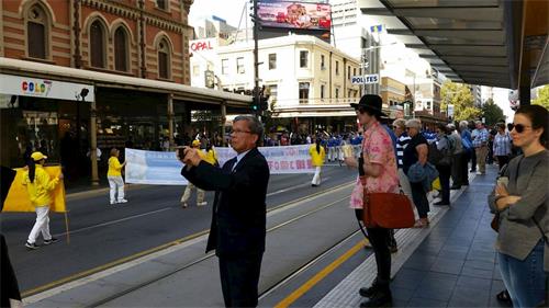 '图2：南澳首府阿德莱德市中心，民众驻足观看声援三亿人三退的游行队伍'