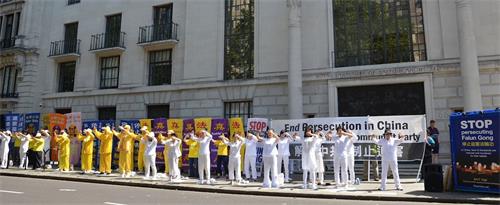 '图1：游行前，英国法轮功学员在伦敦中共使馆街对面集体炼功。'