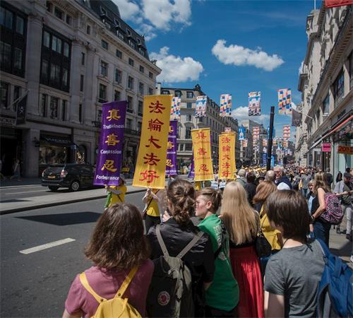 '图2～4：游行队伍在伦敦市中心的街道上庄严行进。'
