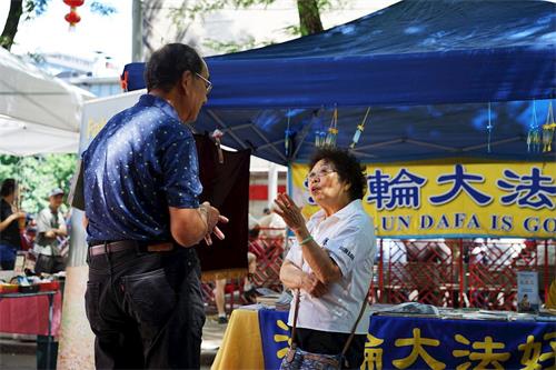 '图1～3：法轮功学员在波士顿中国城主街联欢会上向游客讲真相'
