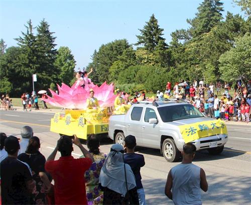 '图6～7：二零一八年七月一日，多伦多法轮功学员的天国乐团和莲花花车当天应邀参加下午两点多伦多市士嘉堡的加拿大国庆游行。'