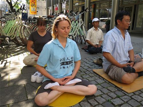 '图4：法轮功学员Iris（前排左）的T恤衫上写着：“中国人好，中共不好，法轮大法好”，她来慕尼黑给中国游客讲真相。'