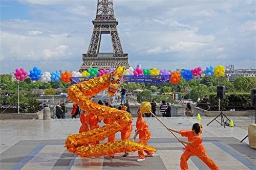 '图6：巴黎法轮功学员庆祝法轮大法日，表演龙舞'