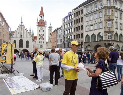 '图1～2：二零一九年六月十日，法轮功学员在德国慕尼黑玛琳广场举办活动，揭露中共迫害法轮功。'