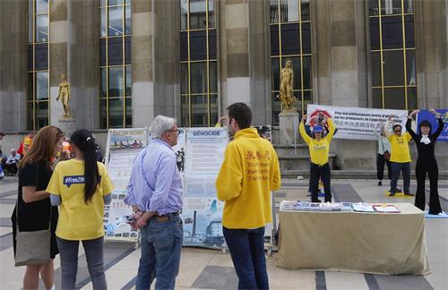 '图1～2：法轮功学员在巴黎人权广场举办活动，介绍功法，并揭露中共对法轮功的迫害。'
