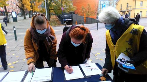 '图1～2：芬兰市民支持法轮功，签名谴责中共暴行。'