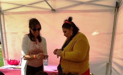 '图9：法轮功学员索菲亚（左）在和一位女士一起制作小莲花挂件，并在交谈中分享自己的修炼体会和法轮功真相。'