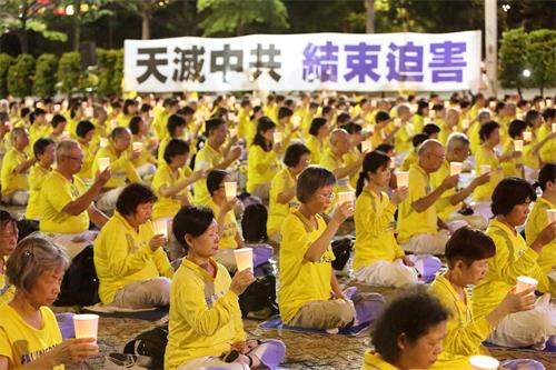 法轮功学员在台北市政府广场前举办反迫害21周年烛光悼念活动。