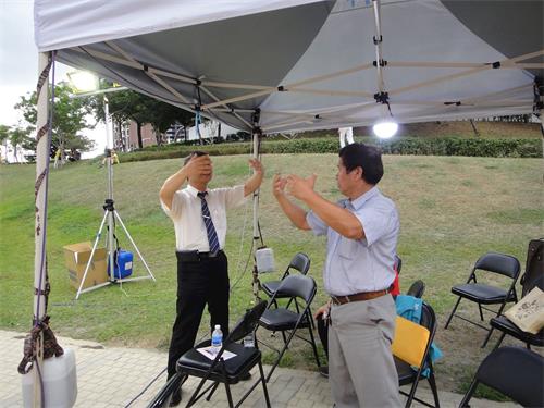 '图7：立法委员汤蕙祯主任秘书黄兴漩（右）在现场跟着学员学炼法轮功第二套功法。'