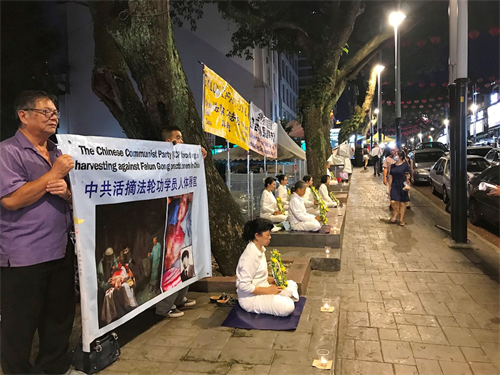 '图5～6：七月十九日晚上，部份法轮功学员在吉隆坡亚罗街（Jalan Alor），悼念被中共迫害的法轮功学员。'