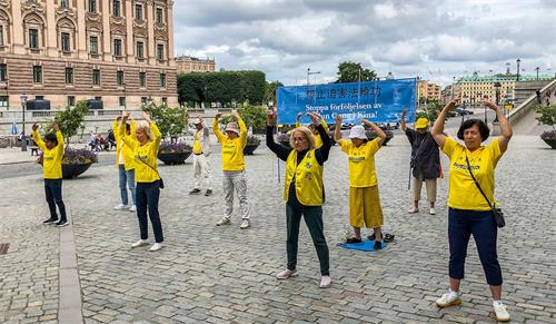 '图1：法轮功学员在斯德哥尔摩市中心国会大厦旁的钱币广场，举办讲真相活动，揭露中共对法轮功长达二十一年的残酷迫害。'