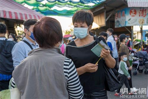 '图4：一位女士想学炼，向法轮功学员询问修炼方法和炼功点资讯。'