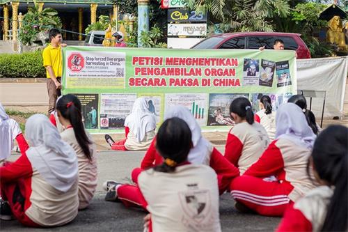 '图12：二零一六年十一月十一日，巴丹岛法轮功学员第二次到Kolese Tiara Bangsa 高职教学生炼法轮功功法。教功后，法轮功学员向Tiara Bangsa 高职学生讲述中共活摘法轮功学员器官的罪行。'