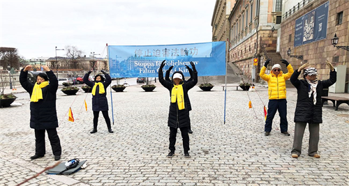'图1：法轮功学员在瑞典国会大厦旁的钱币广场，举办讲真相活动。学员在展示功法。'