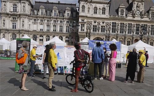 '图2：在巴黎市政厅广场，人们在观看展板，向法轮功学员了解真相'