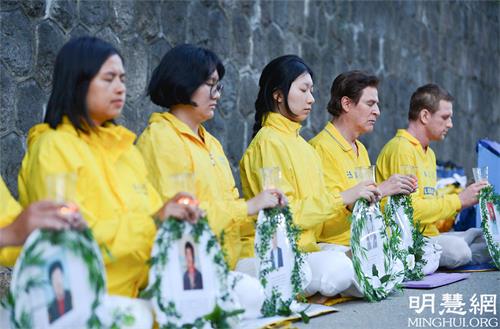 '图1～7：二零二一年七月十八日晚，部份温哥华法轮功学员静静地坐在中领馆前，举办烛光夜悼，呼吁停止迫害，制裁迫害者。'