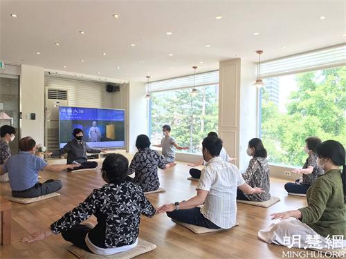 '图1：韩国首尔天梯书店法轮大法九天班（上午班）的学员正在学习法轮功炼功动作。'