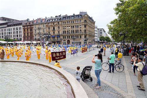 '图1：二零二一年八月七日，法轮功学员在德国法兰克福举办大型集会游行活动，吸引了人们的目光。'