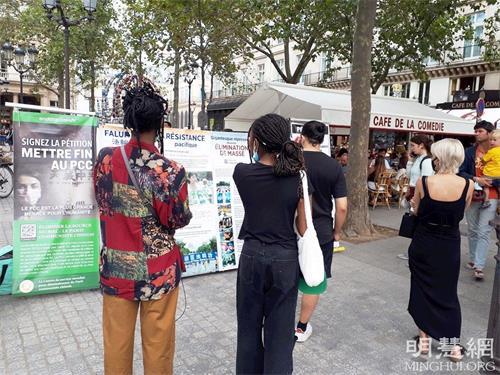 '图4：巴黎民众在柯莱特广场观看展板，了解法轮功真相。'