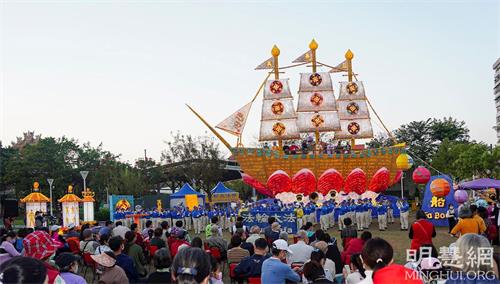 '图1：二月一日至二月二十八日，巨型“法船”花灯于高雄冈山公园展出一个月，天国乐团和腰鼓队前来表演，数万民众纷至沓来，登船祈福，体验美好善愿的传统习俗。。'