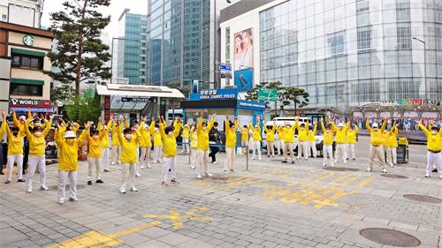 '图4: 韩国法轮功学员在中使馆前集体炼功。'