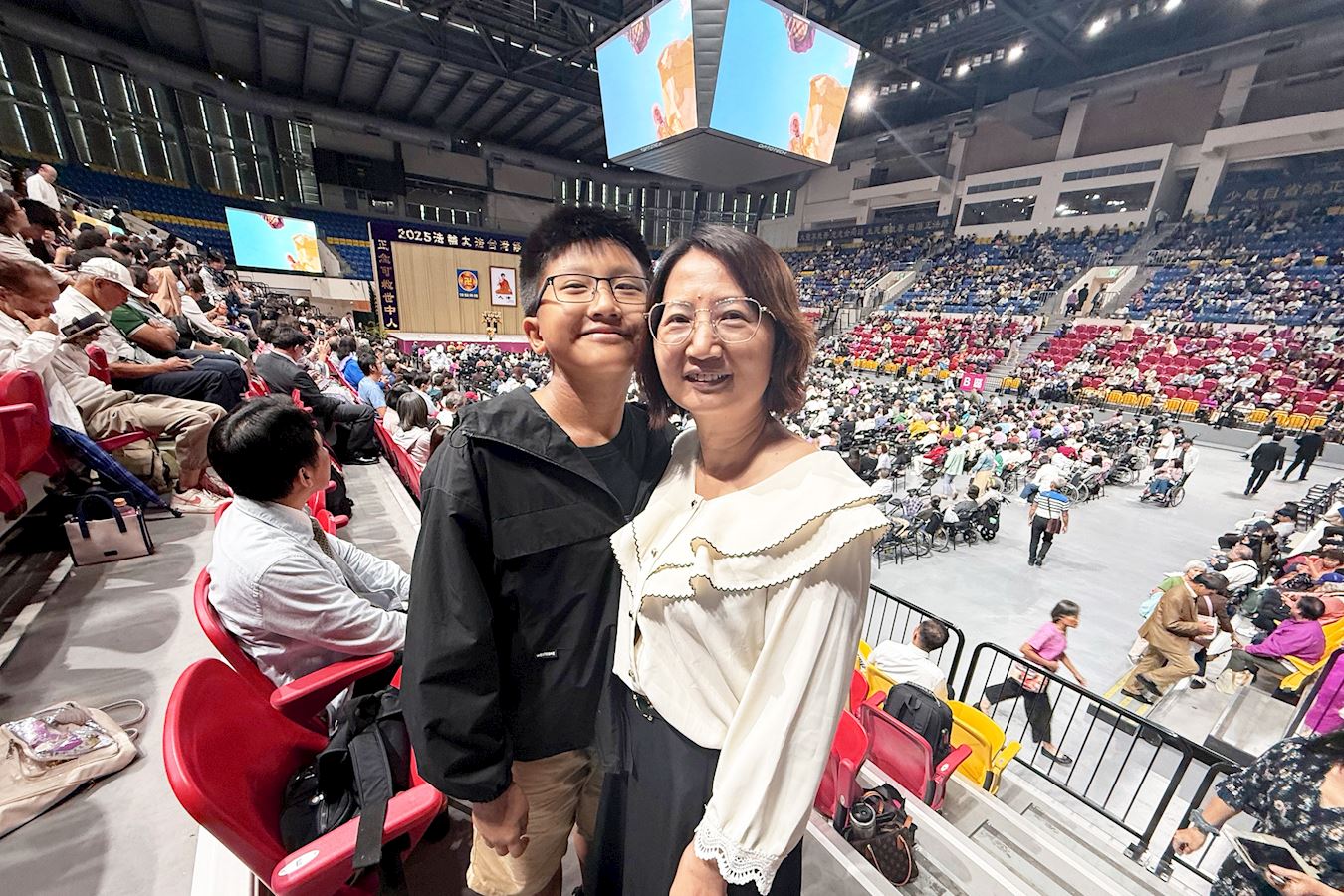 '图2:来自台中的许淑卿和孩子在法会主厅合影。'